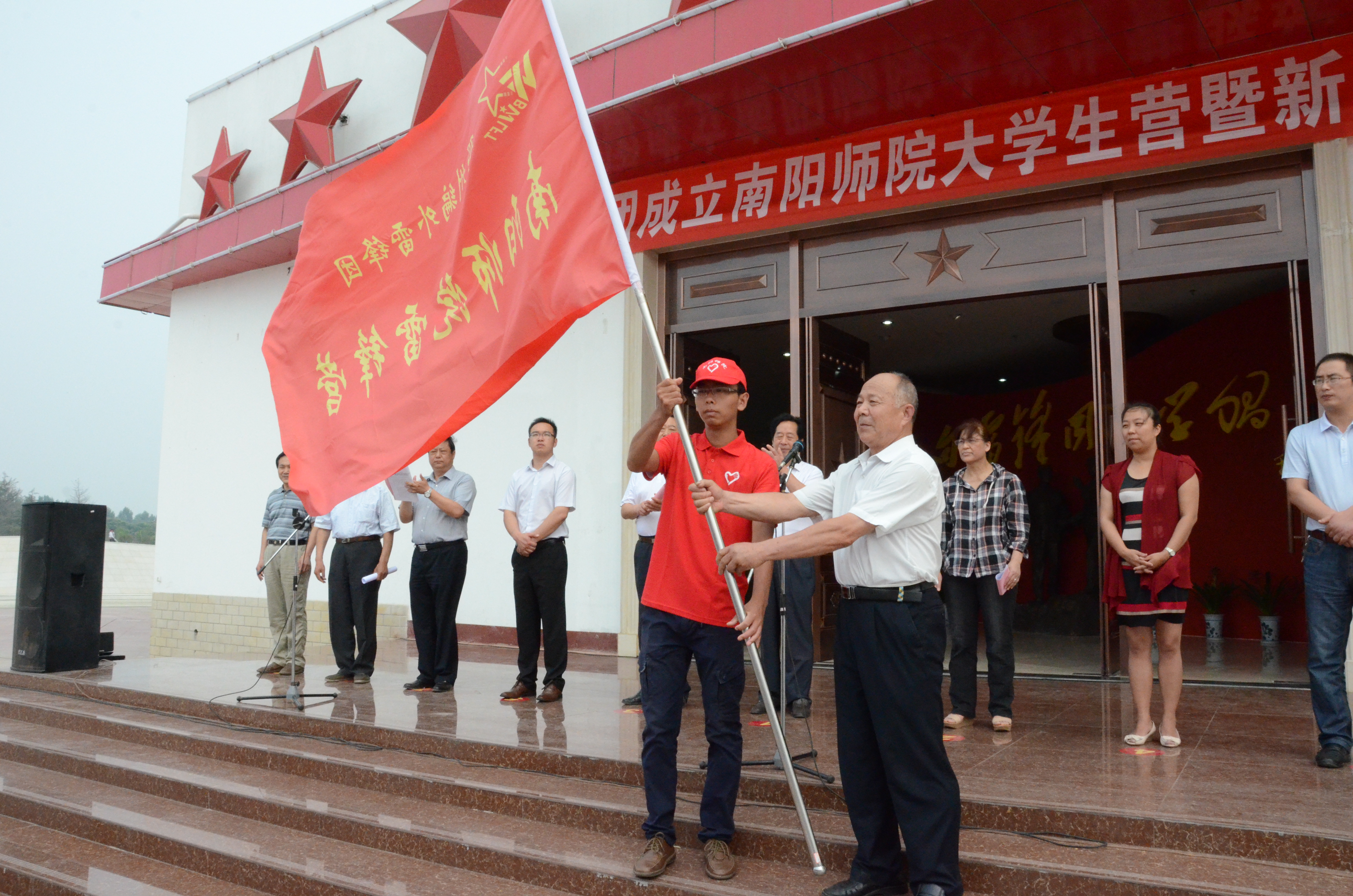 2邓州市编外雷锋团团长宋清梅向新葡的京官网授予大学生雷锋营旗帜.JPG