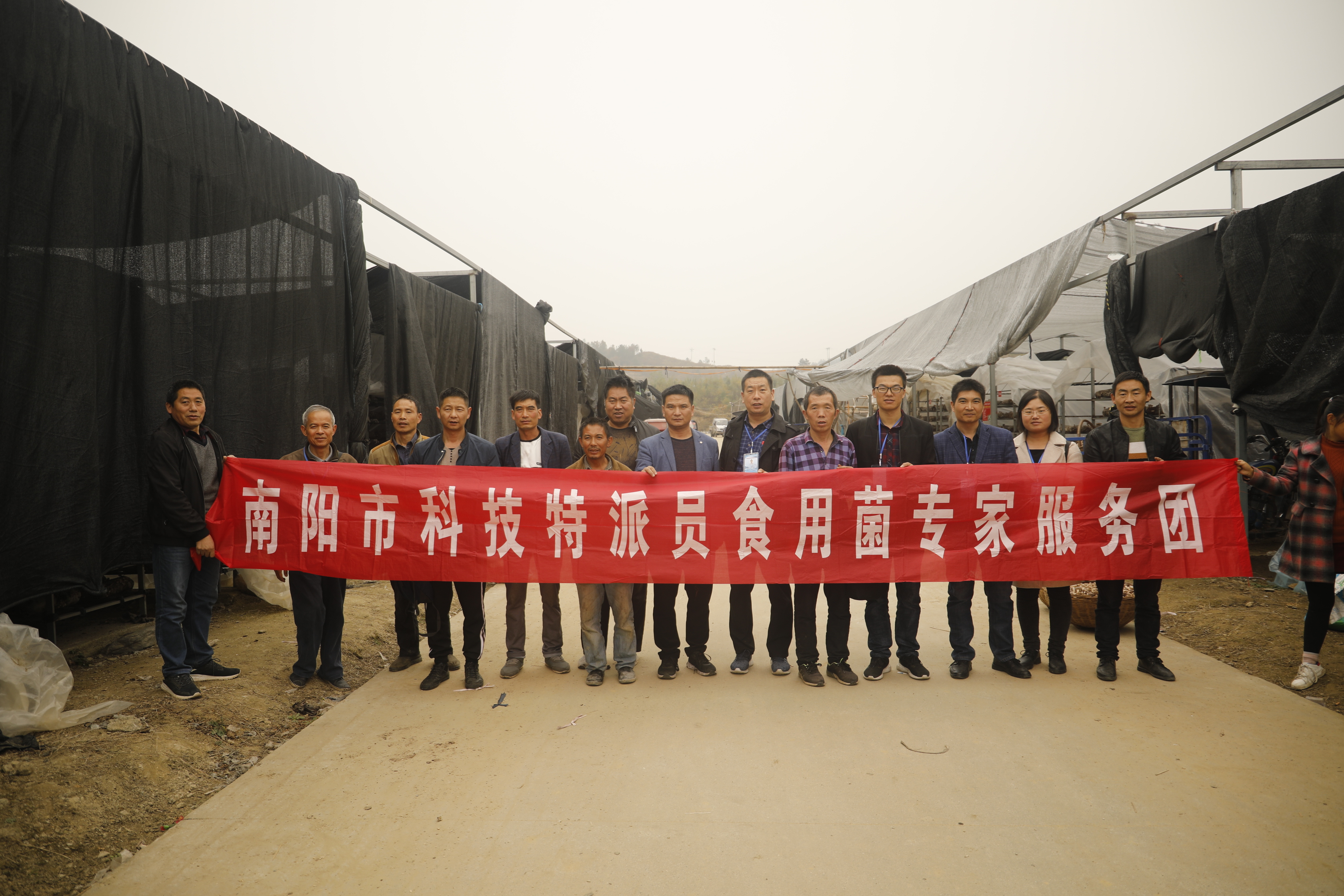 服务团在西峡县西坪镇牧牛岭社区香菇基地与贫困户合影.JPG